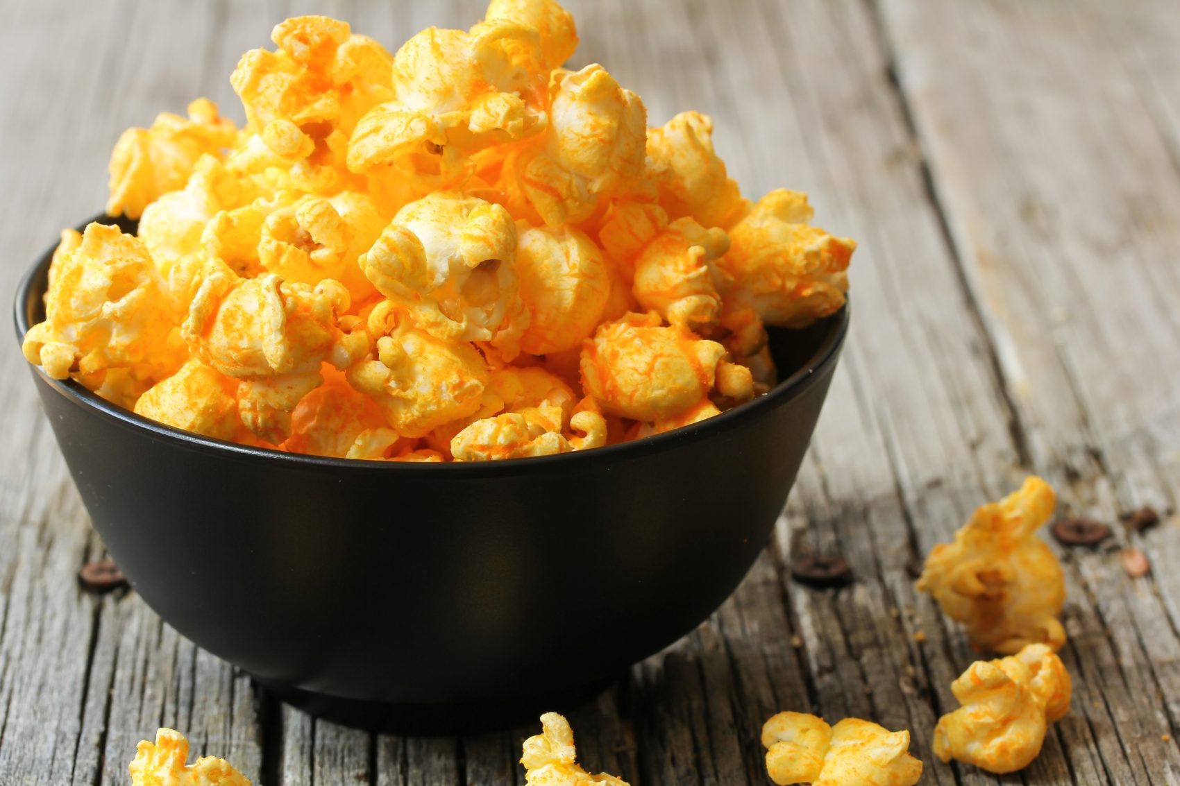 Cheese popcorn in a black bowl, selective focus | All American Foods